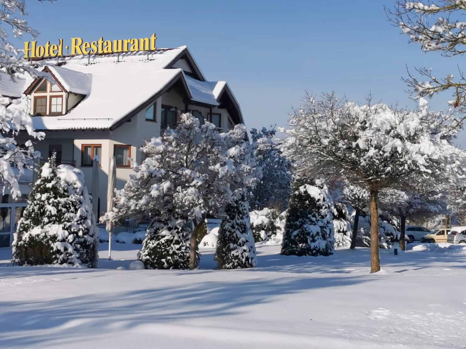 Verschneites Hotelrestaurant mit Bäumen im Winter